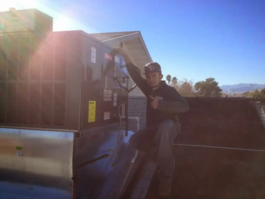HVAC technician performing HVAC Inspection on a rooftop unit in Bloomer